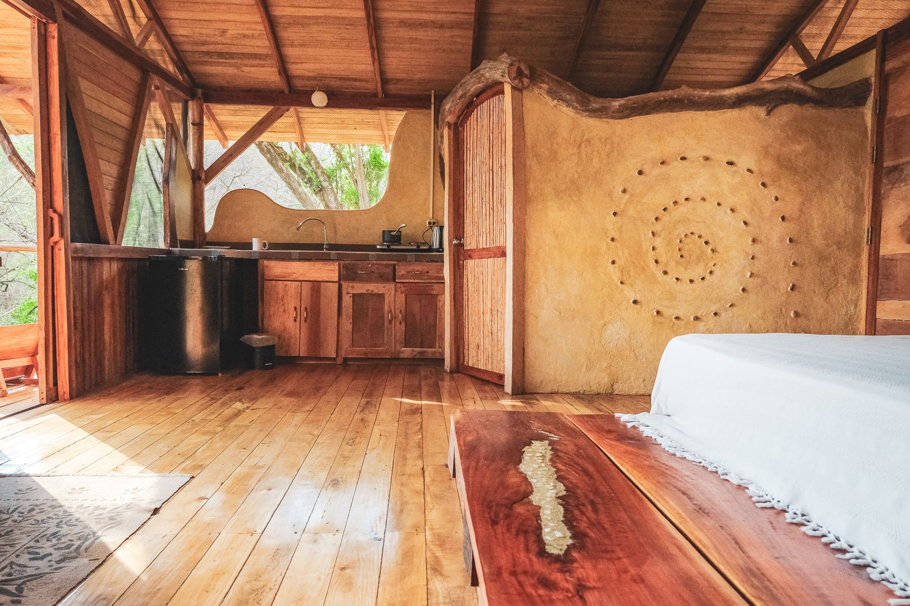 Wooden casita interior with a hand-painted spiral wall, Costa Rica