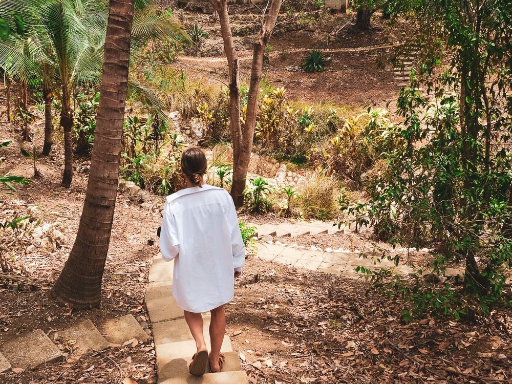 A guest walking down a stone path through the jungle toward a casita at Alya, Costa Rica